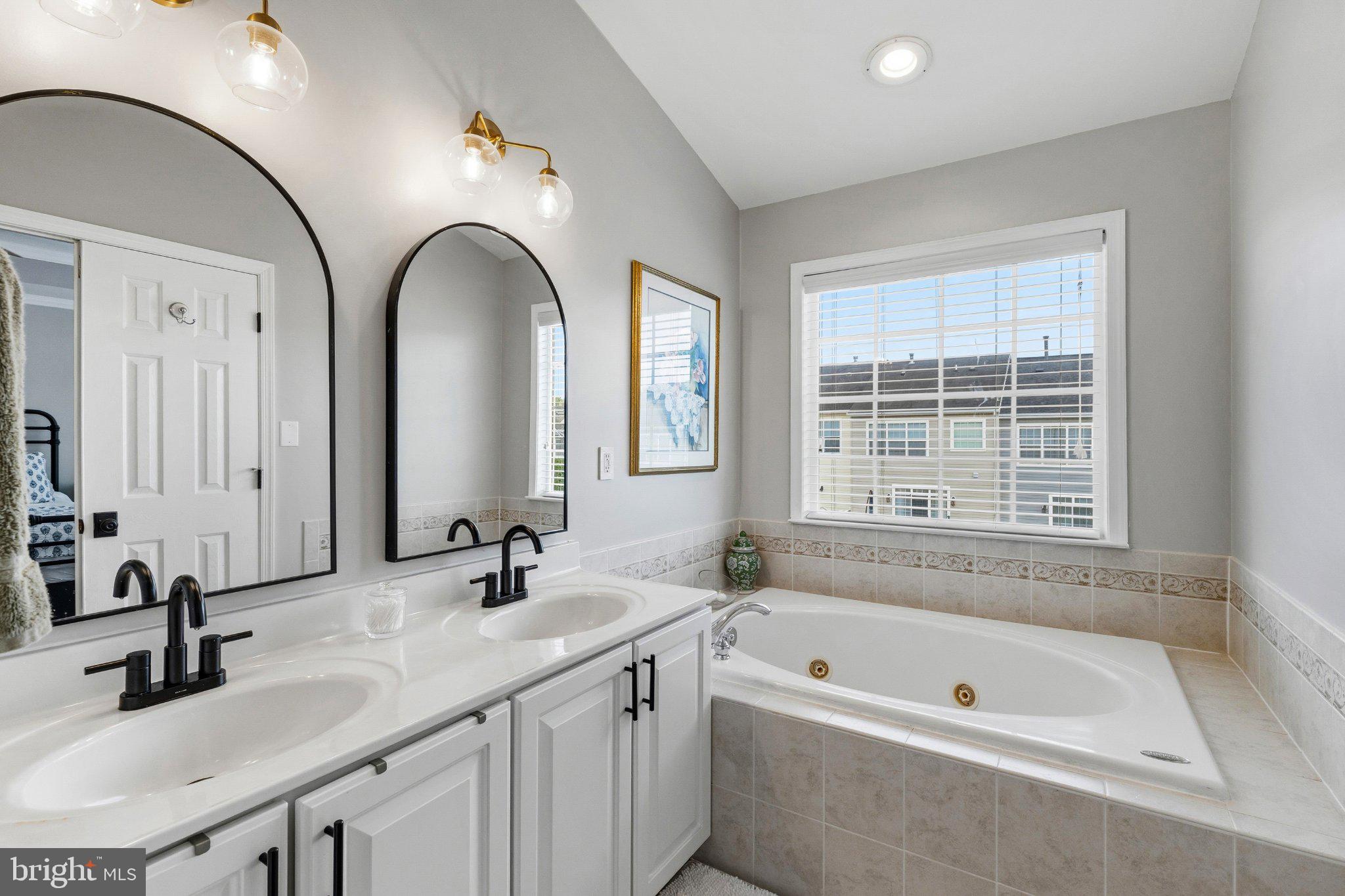 2668 Merlin Court Odenton, MD 21113 - Photo 20 of 42 a bathroom with a tub a sink and a window