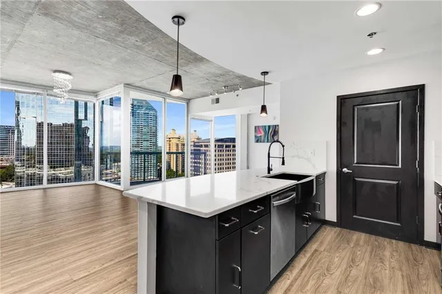 a kitchen with a refrigerator a sink and wooden floor