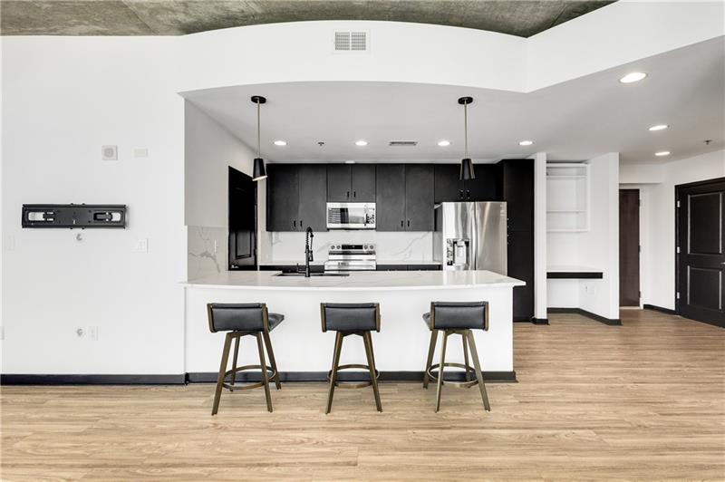 3324 Peachtree Road Northeast, Unit 1419 Atlanta, GA 30326 - Photo 11 of 43 a kitchen with stainless steel appliances granite countertop a table chairs sink and cabinets