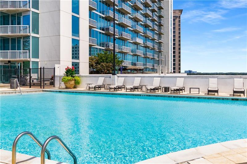 3324 Peachtree Road Northeast, Unit 1419 Atlanta, GA 30326 - Photo 34 of 43 a view of a swimming pool with a garden and trees