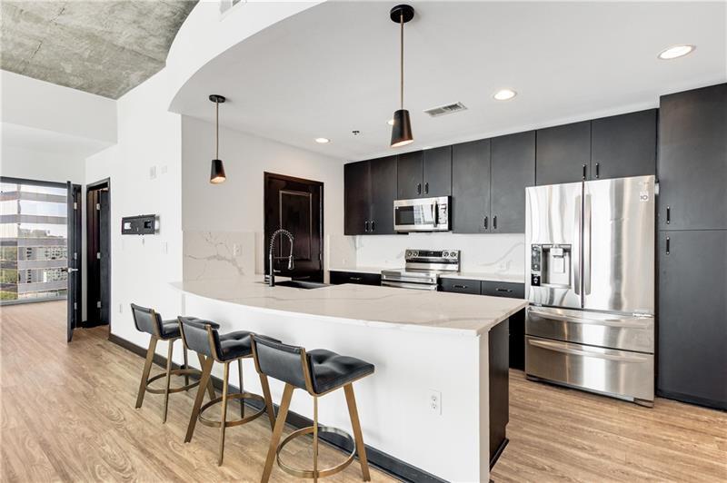 3324 Peachtree Road Northeast, Unit 1419 Atlanta, GA 30326 - Photo 4 of 43 a kitchen with stainless steel appliances a refrigerator stove microwave and cabinets