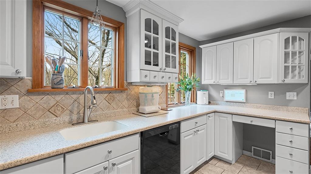 4720 Rolling Hills Road Pittsburgh, PA 15236 - Photo 11 of 34 a kitchen with stainless steel appliances granite countertop white cabinets a sink and a window