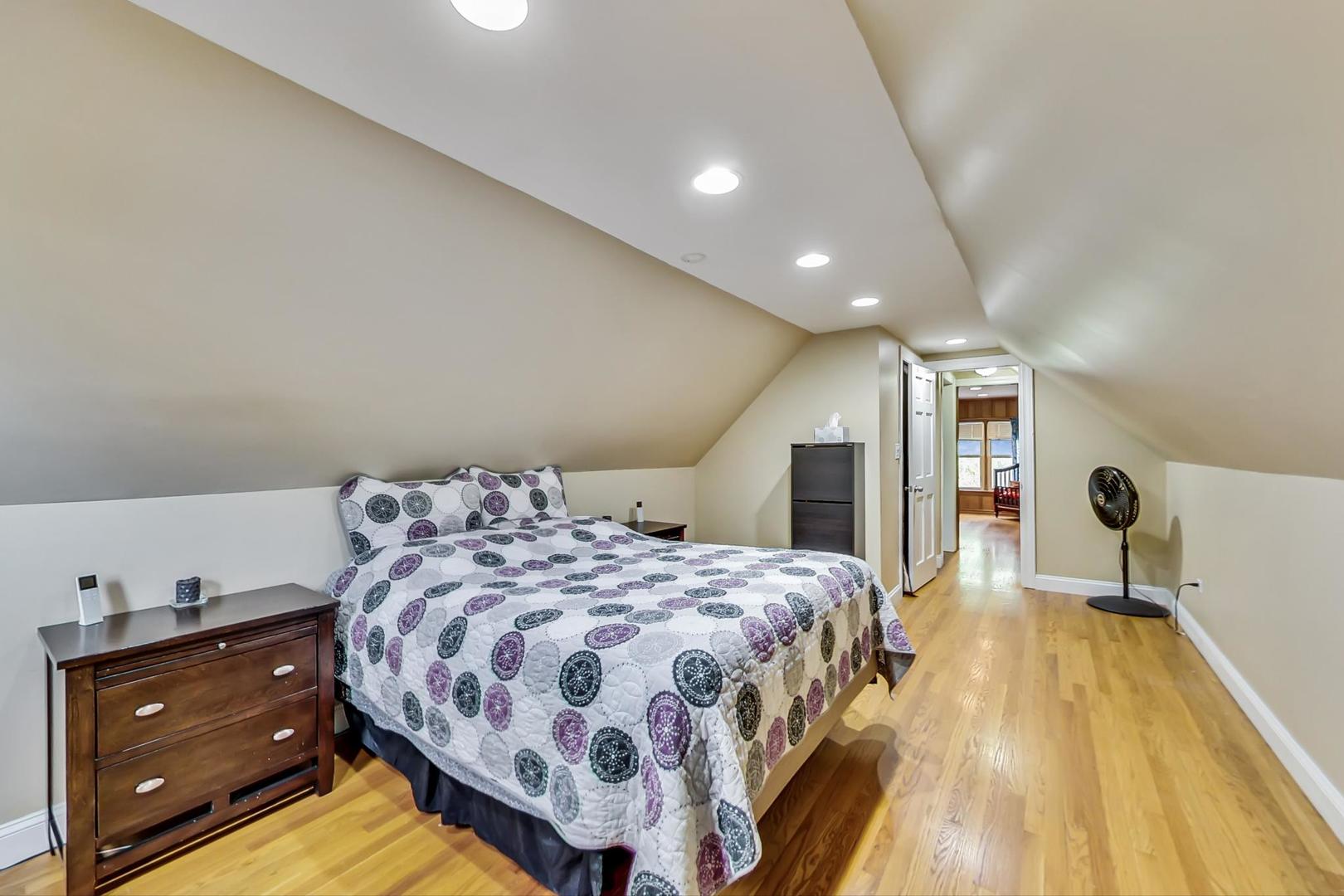 1218 Elliott Street Park Ridge, IL 60068 - Photo 14 of 24 a spacious bedroom with a bed and a flat tv screen on a dresser