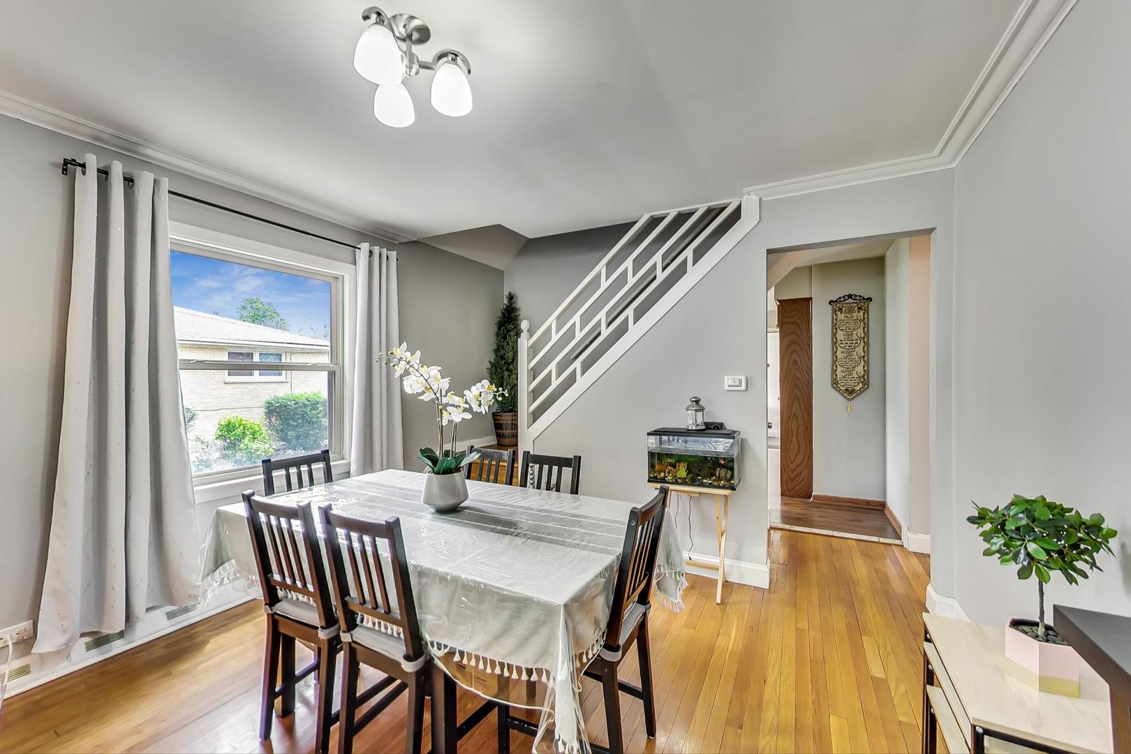 1218 Elliott Street Park Ridge, IL 60068 - Photo 6 of 24 a dining room with wooden floor a chandelier a wooden table and chairs