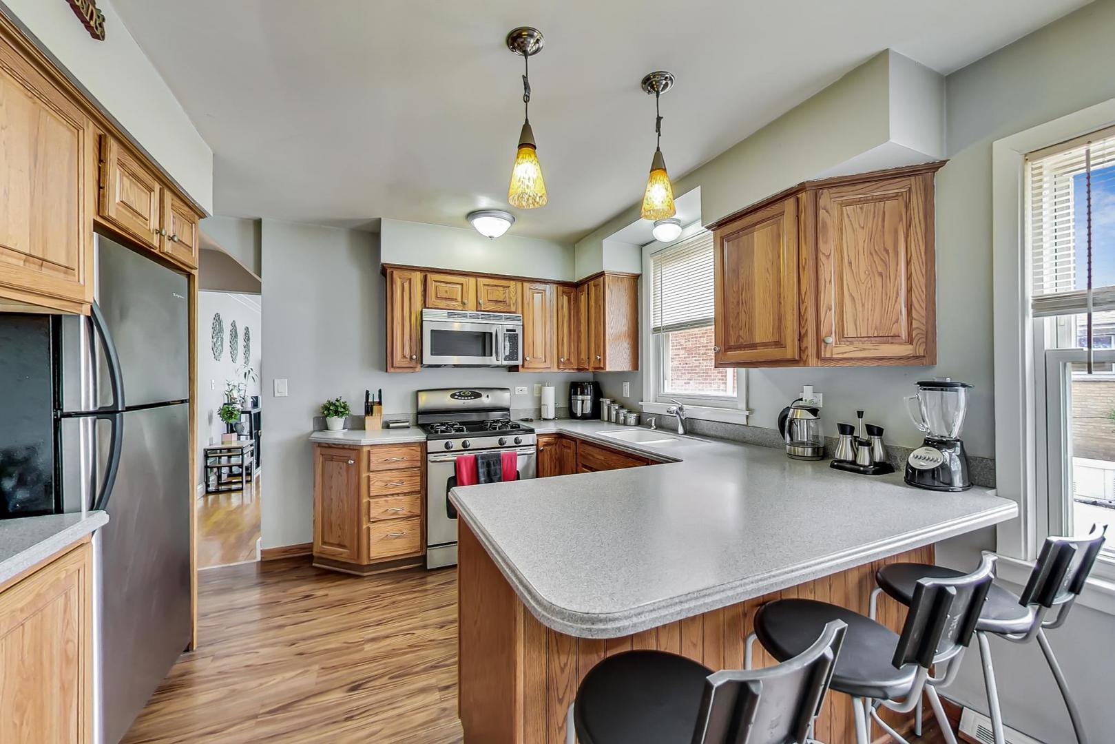 1218 Elliott Street Park Ridge, IL 60068 - Photo 8 of 24 a kitchen with a table chairs refrigerator and cabinets