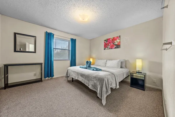 a bedroom with bed and night stand