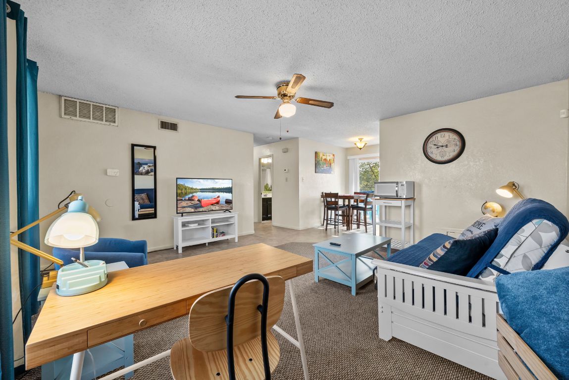 202 West Wheeler Street Manor, TX 78653 - Photo 27 of 28 a living room with furniture a window and a chandelier