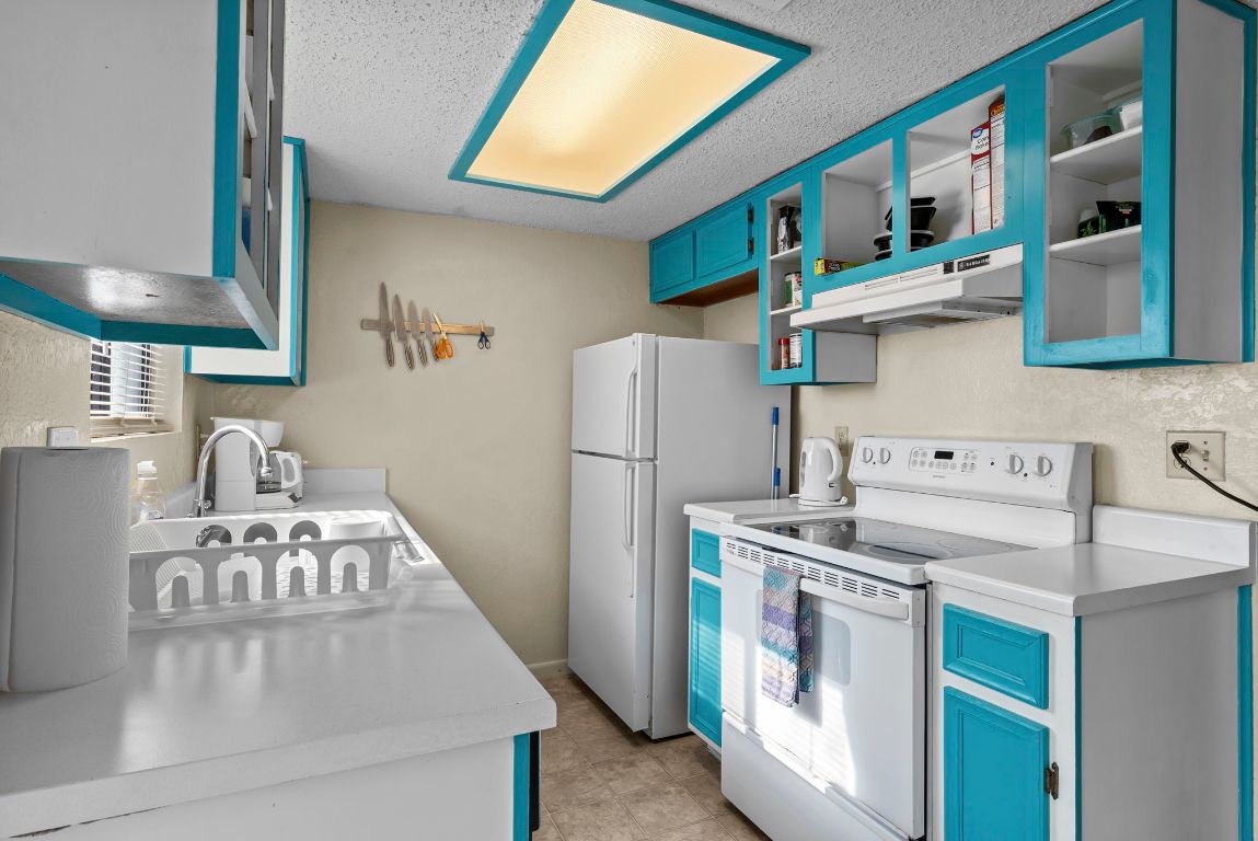 202 West Wheeler Street Manor, TX 78653 - Photo 5 of 28 a kitchen with a stove and a refrigerator