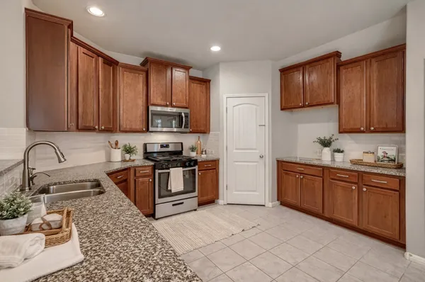 a kitchen with stainless steel appliances granite countertop a stove sink and cabinets