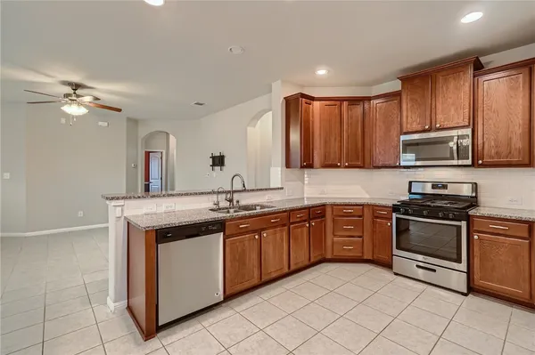 a kitchen with stainless steel appliances granite countertop a sink and stove top oven
