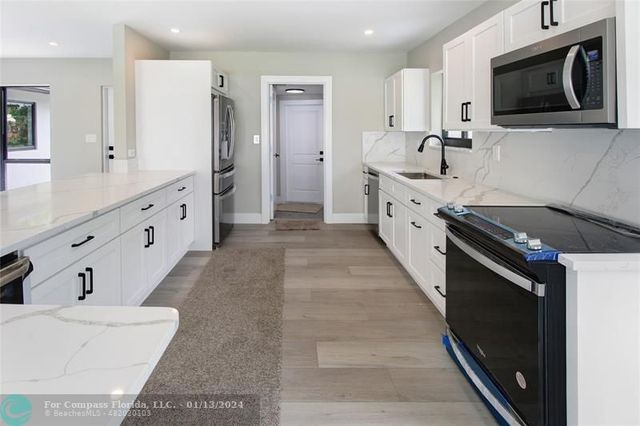 a large white kitchen with stainless steel appliances