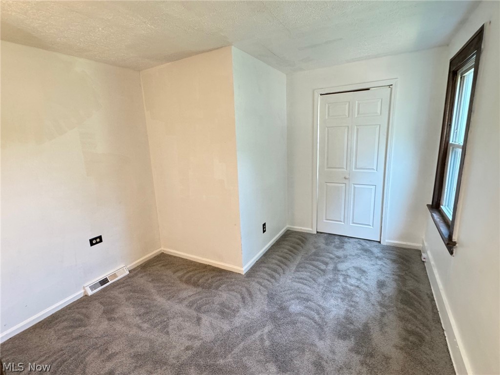459 Patterson Avenue Akron, OH 44310 - Photo 22 of 24 1st floor apt. bedroom with a textured ceiling, a closet, and dark carpet