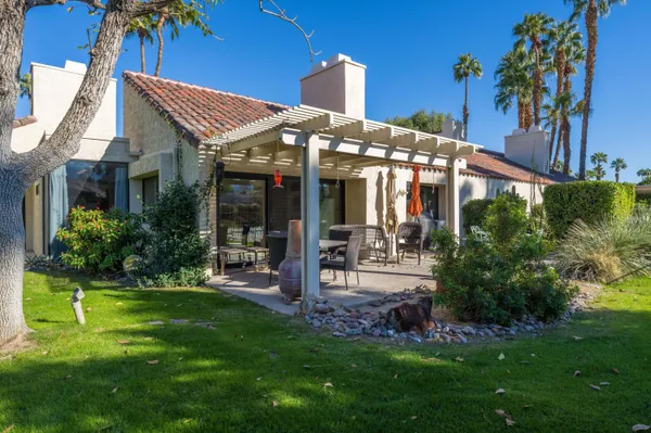 a view of a house with a yard and potted plants