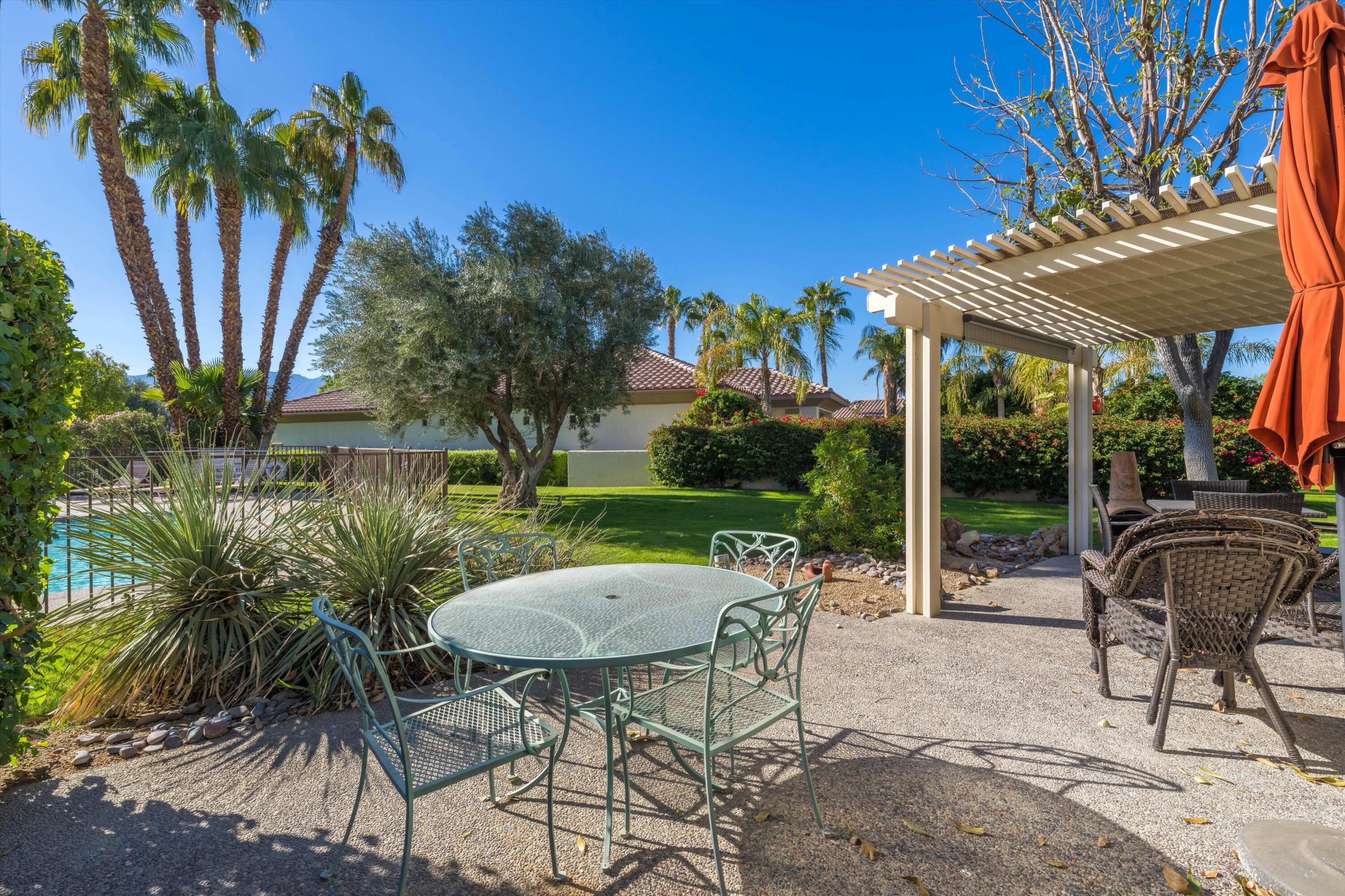 464 Sunningdale Drive Rancho Mirage, CA 92270 - Photo 21 of 47 a view of a patio with table and chairs potted plants and palm tree