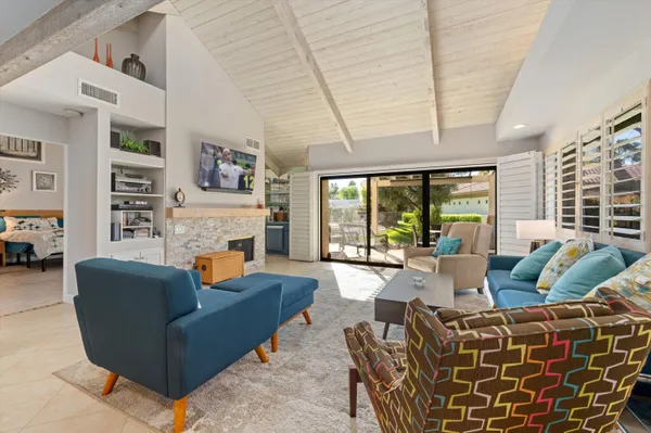 a living room with furniture a fireplace and a large window