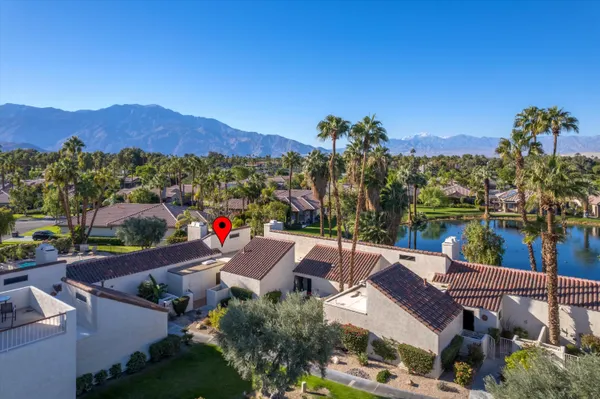 an aerial view of a house with a garden and lake view