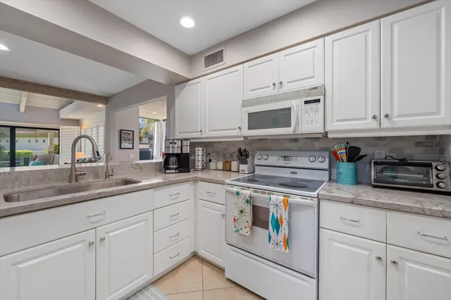 a kitchen with appliances a sink and cabinets
