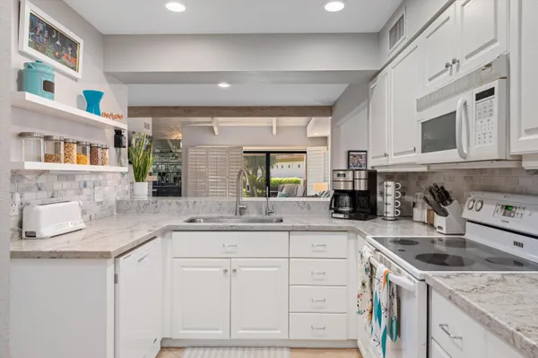 a kitchen with cabinets appliances a sink and a counter top space