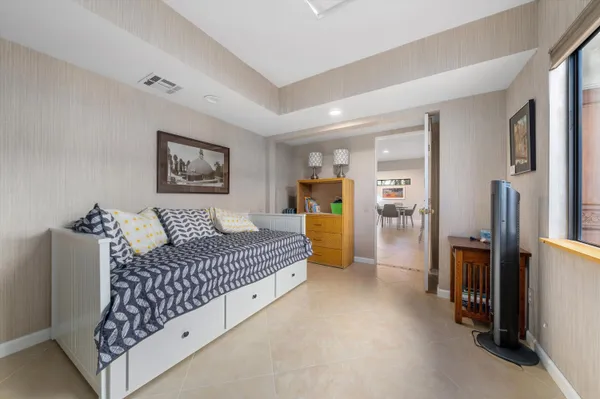 a spacious bedroom with a bed and a chandelier