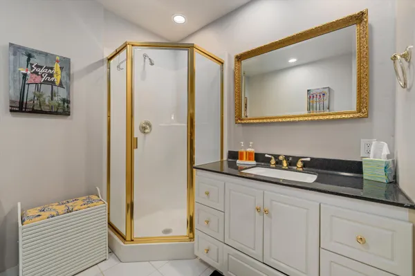 a bathroom with a sink a mirror a vanity and shower