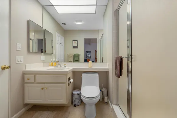 a bathroom with a toilet a sink a vanity and mirror