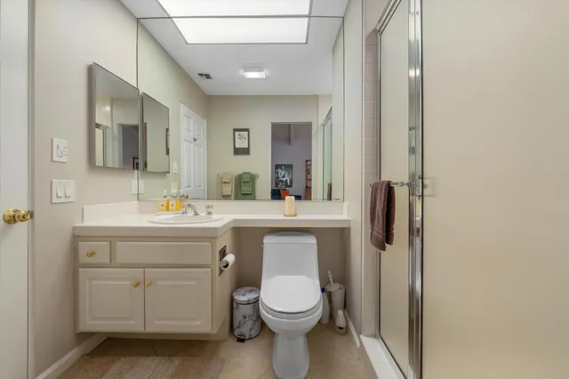 a bathroom with a toilet a sink a vanity and mirror