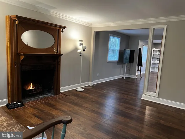 a view of a livingroom with wooden floor and a fireplace