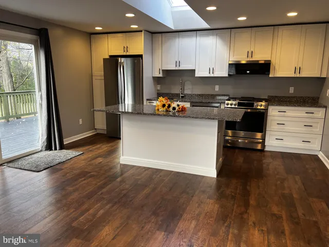 a kitchen with granite countertop a refrigerator and a stove