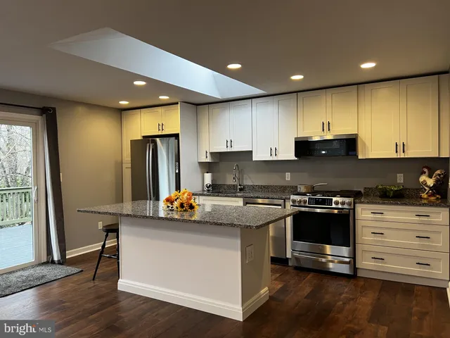 a kitchen with stainless steel appliances granite countertop a stove a sink and a refrigerator