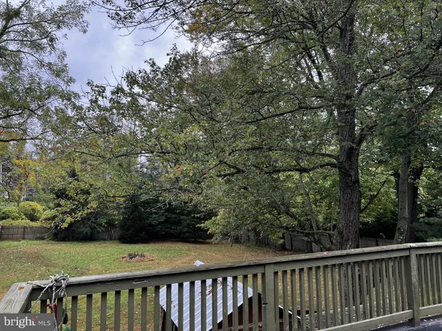 a view of a green field with wooden fence