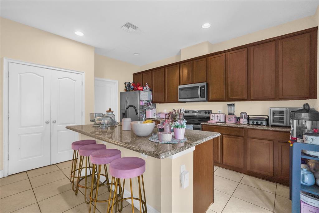 12353 Via Derna Place Windermere, FL 34786 - Photo 11 of 26 a kitchen with stainless steel appliances granite countertop a sink dishwasher and cabinets with wooden floor
