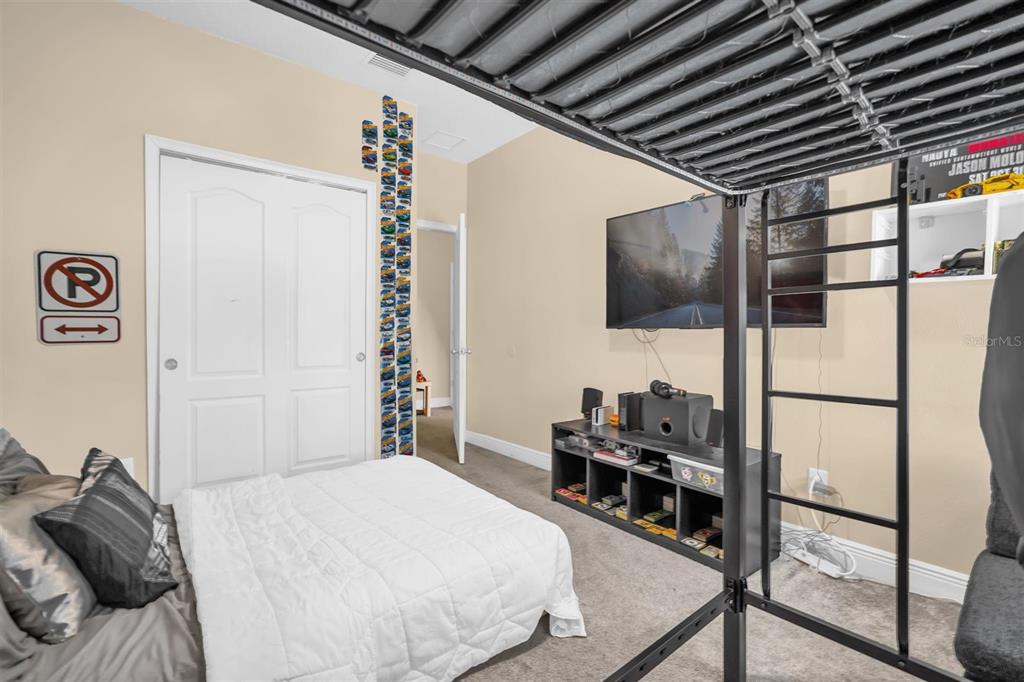 12353 Via Derna Place Windermere, FL 34786 - Photo 17 of 26 a bedroom with a bed a flat screen tv and a window