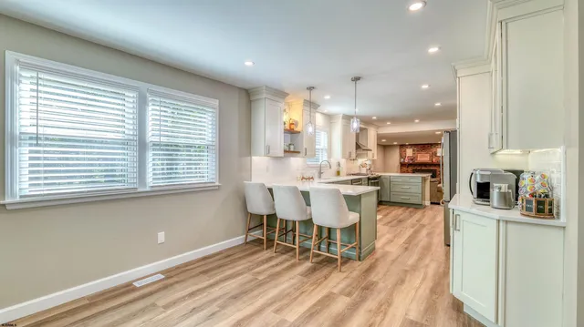 a kitchen with a dining table chairs and large window