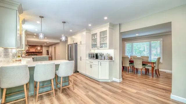 a kitchen with a table chairs sink and refrigerator