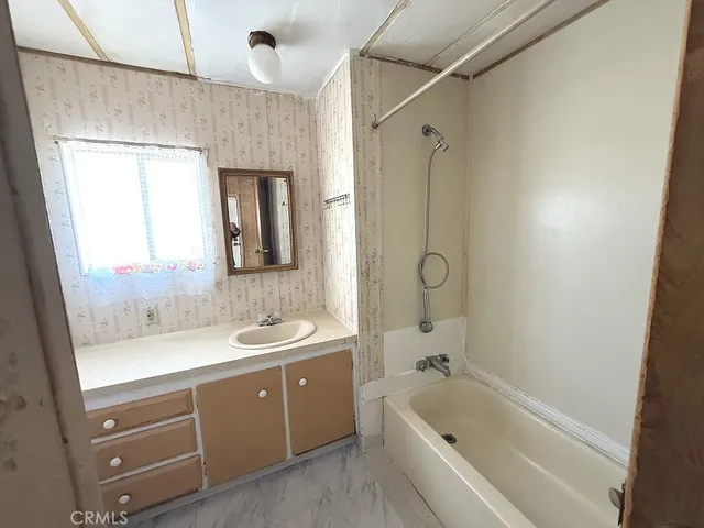 a bathroom with a tub sink and mirror