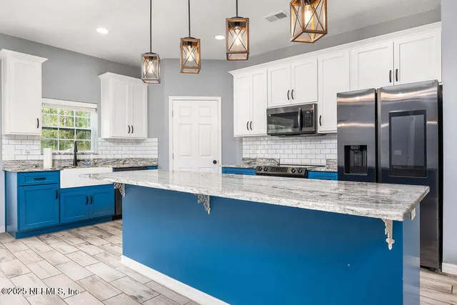 a kitchen with stainless steel appliances granite countertop a sink a stove counter space and cabinets
