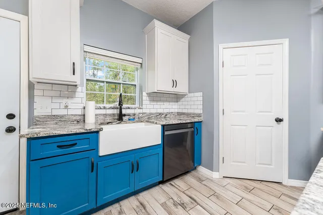 a kitchen with granite countertop a sink and a stove