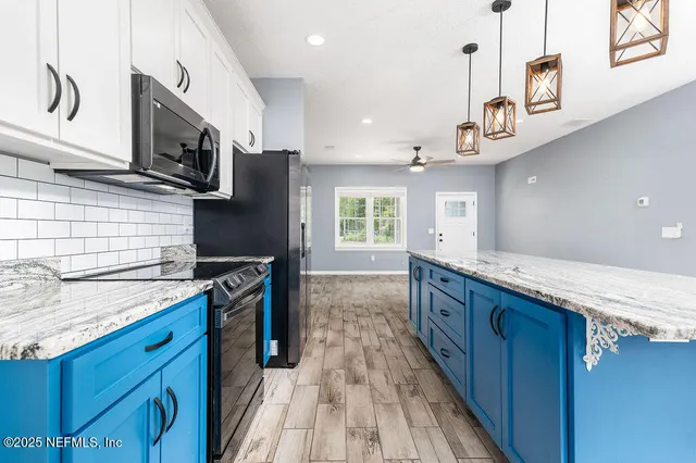 a kitchen with stainless steel appliances granite countertop a stove a sink and a refrigerator