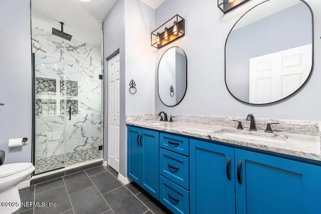 a bathroom with a double vanity sink mirror and toilet