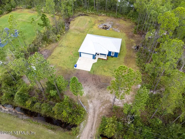 an aerial view of a house with a yard