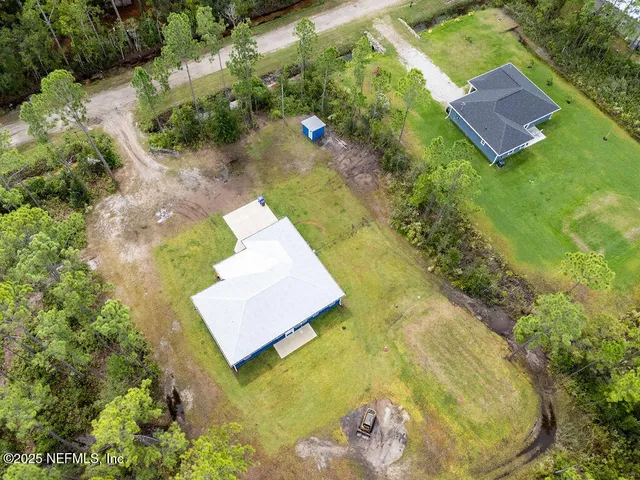 an aerial view of a house with swimming pool and garden