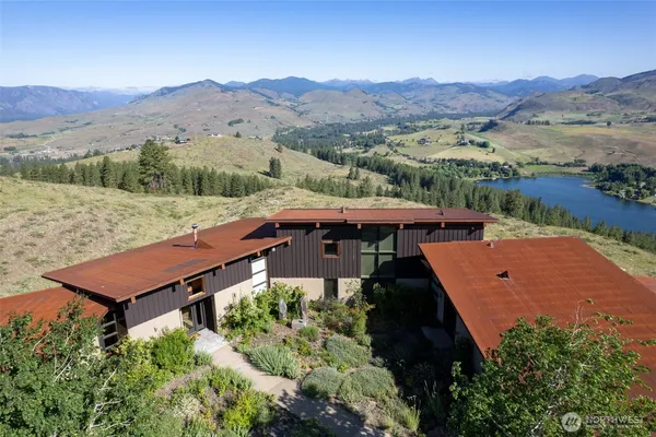 an aerial view of a house with a mountain