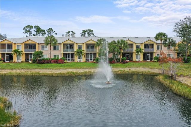 a front view of a house with a yard and lake view