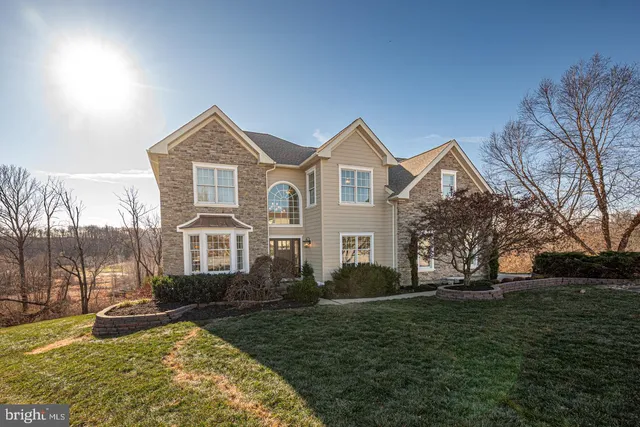a front view of a house with a yard and trees