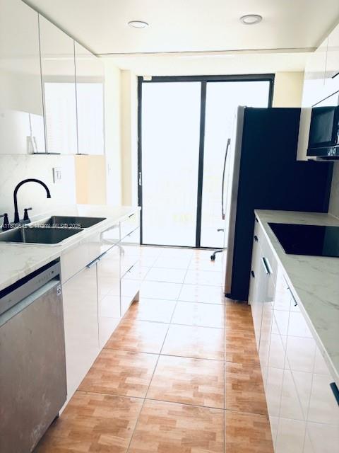 210 174th Street, Unit 818 Sunny Isles Beach, FL 33160 - Photo 8 of 25 a kitchen with stainless steel appliances a refrigerator sink and cabinets