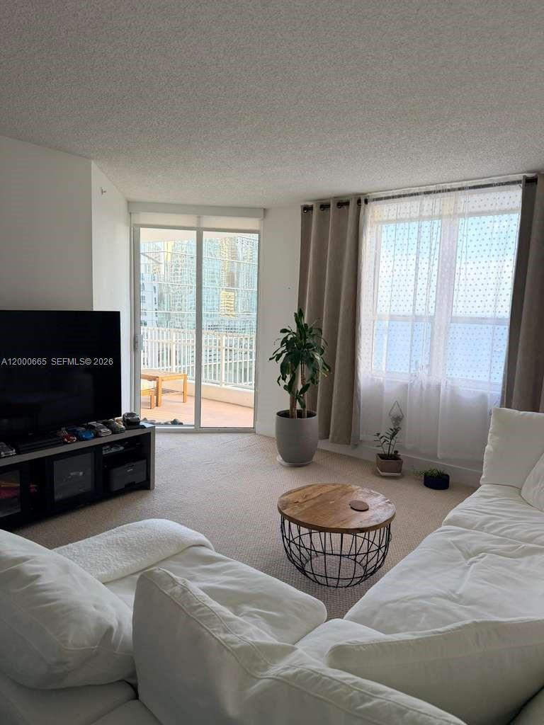 701 Brickell Key Boulevard, Unit 1501 Miami, FL 33131 - Photo 3 of 8 a bedroom with furniture and a flat screen tv