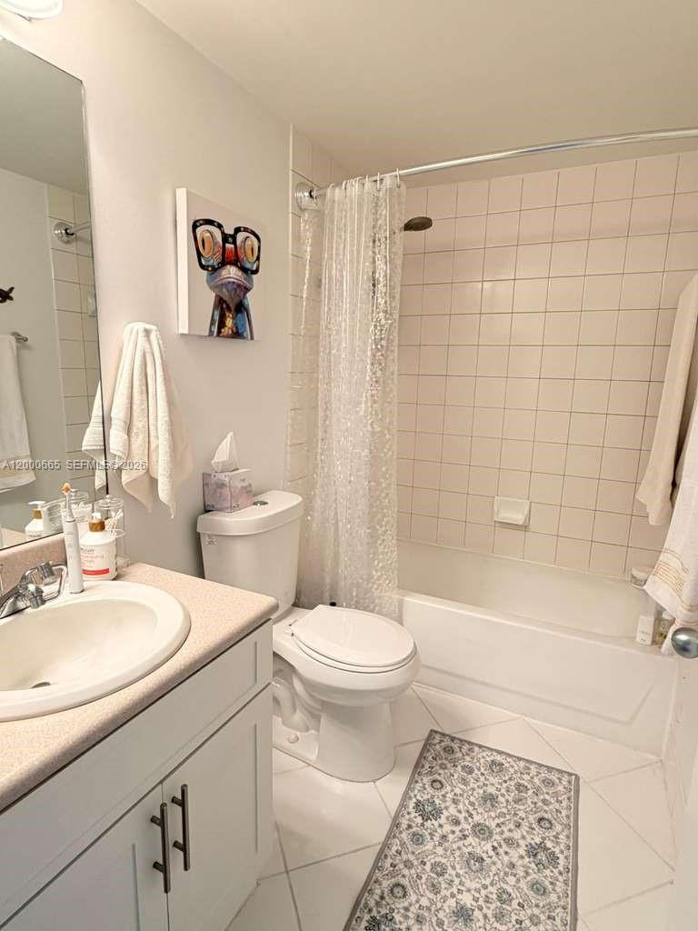 701 Brickell Key Boulevard, Unit 1501 Miami, FL 33131 - Photo 7 of 8 a bathroom with a sink a toilet and shower curtain