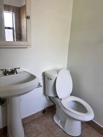 a bathroom with a toilet sink and mirror