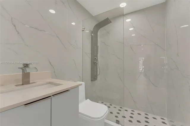 a bathroom with a sink a toilet and shower