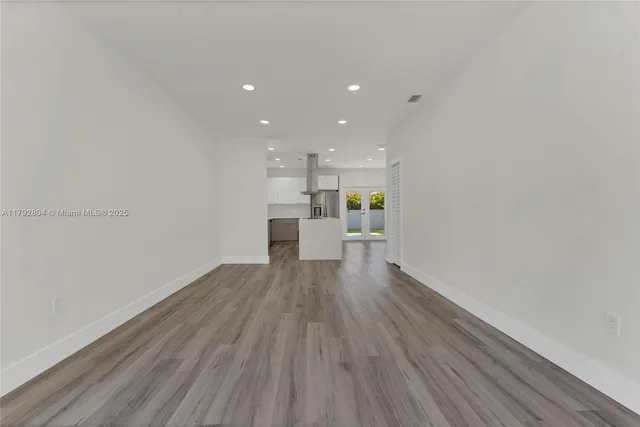 a view of a kitchen with wooden floor and a sink